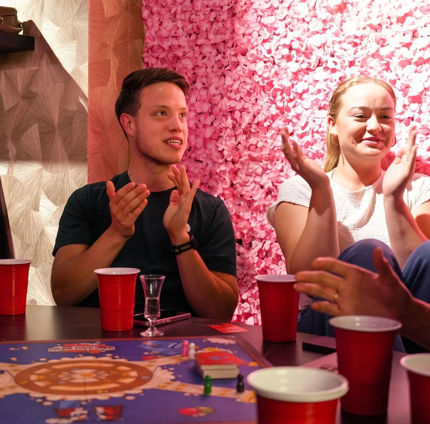 Groep klapt en lacht rond het spelbord